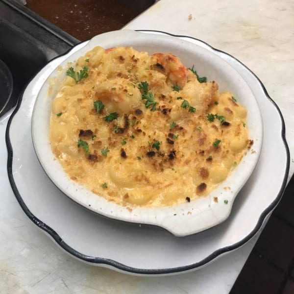 Baked mac and cheese with shrimp and parsley in a white scalloped dish at Galaxy Diner.